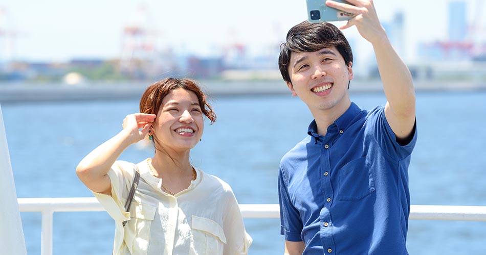 船の甲板で写真撮影をするカップル。結婚祝いにもおすすめ