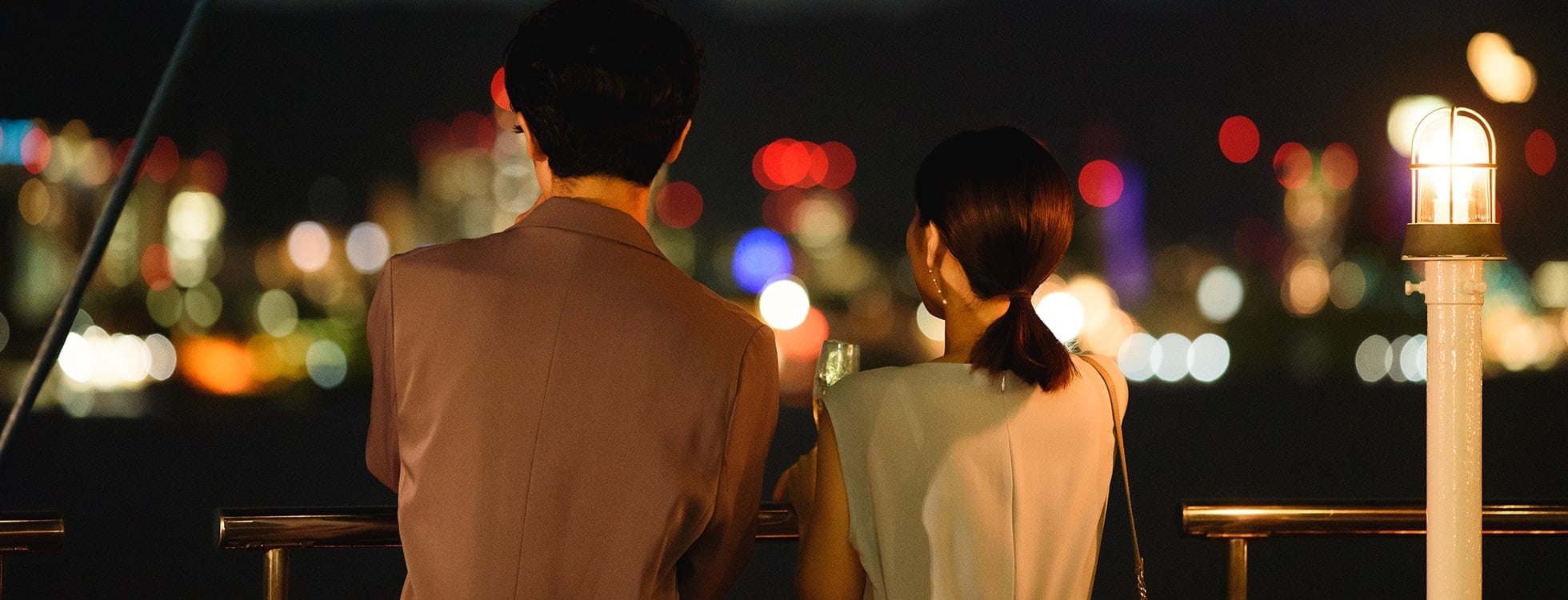 ロイヤルウイングの船内から横浜の夜景を楽しむ夫婦