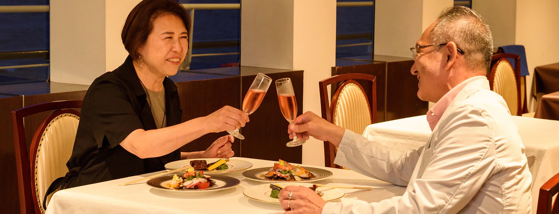 横浜ロイヤルウイングの豪華なディナーを楽しむ夫婦